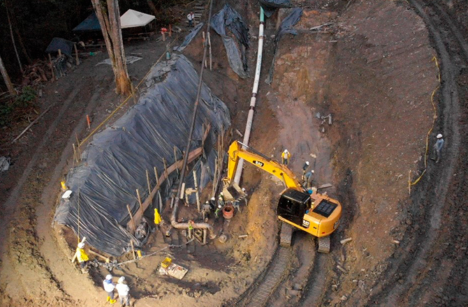 Cinco operarios de TGI realizan una maniobra en zona excavada con tuberías