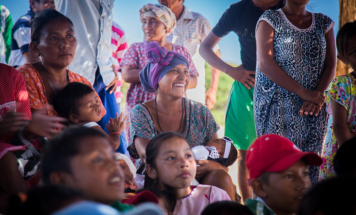 Madres de la comunidad wayú están junto a sus hijos sonriendo